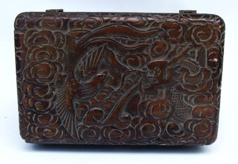 An old Chinese carved wood jewelry box with detailed Dragon and birds decoration