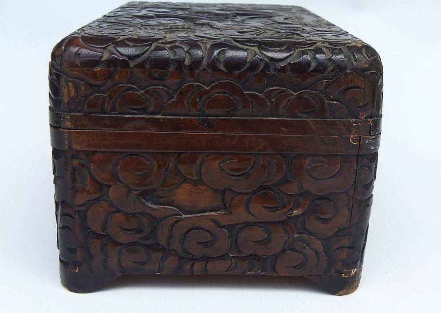 An old Chinese carved wood jewelry box with detailed Dragon and birds decoration