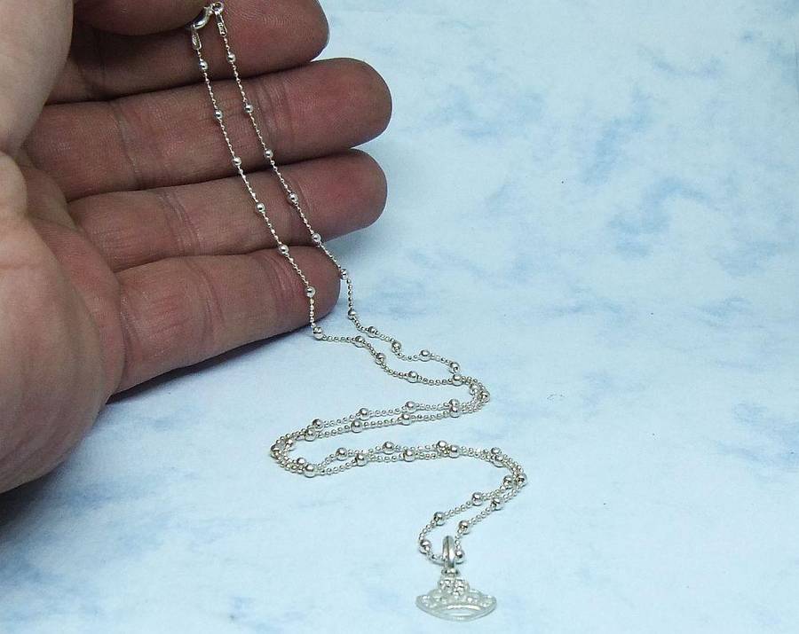 A SOLID STERLING SILVER "BALL" NECKLACE WITH A STERLING SILVER CROWN SHAPED PENDANT