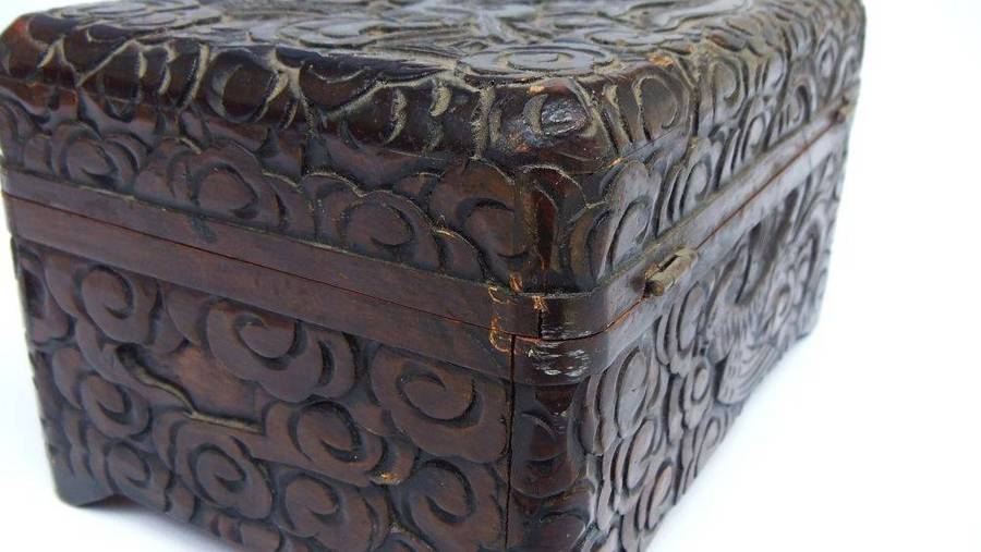 An old Chinese carved wood jewelry box with detailed Dragon and birds decoration