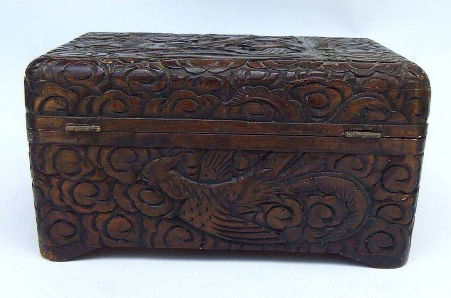 An old Chinese carved wood jewelry box with detailed Dragon and birds decoration