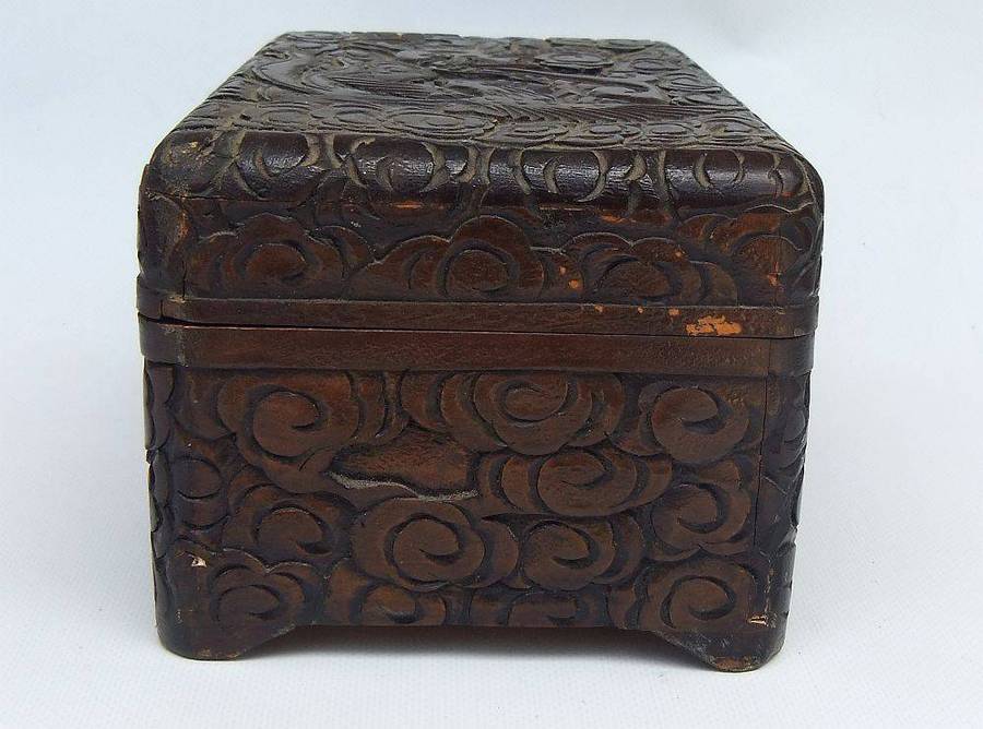 An old Chinese carved wood jewelry box with detailed Dragon and birds decoration
