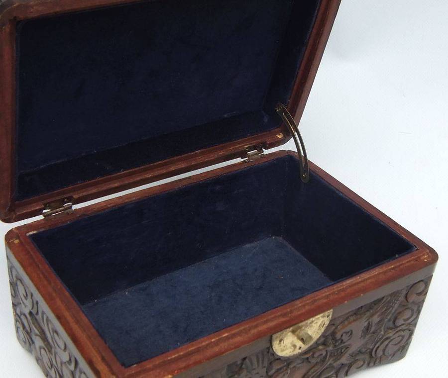 An old Chinese carved wood jewelry box with detailed Dragon and birds decoration