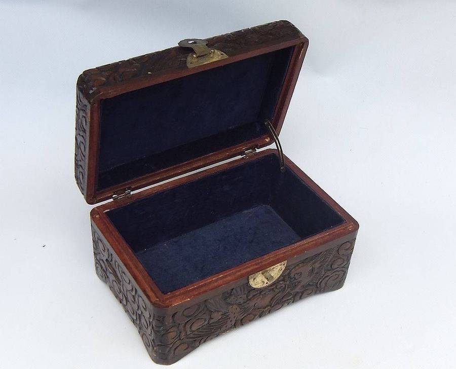An old Chinese carved wood jewelry box with detailed Dragon and birds decoration