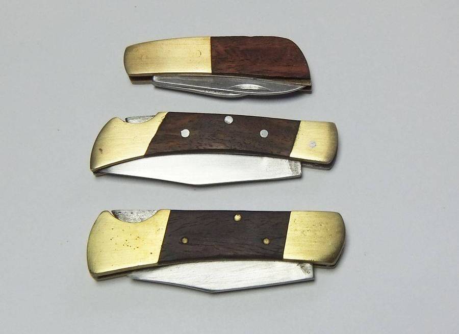 A lot of three vintage brass and wood folding pocket knives