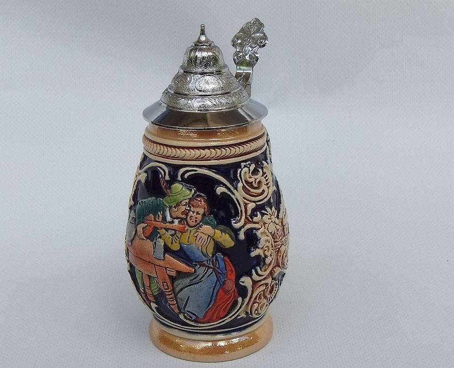 A fabulous vintage German beer stein with hinged metal lid and great detail
