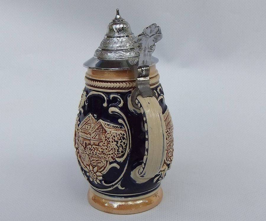 A fabulous vintage German beer stein with hinged metal lid and great detail