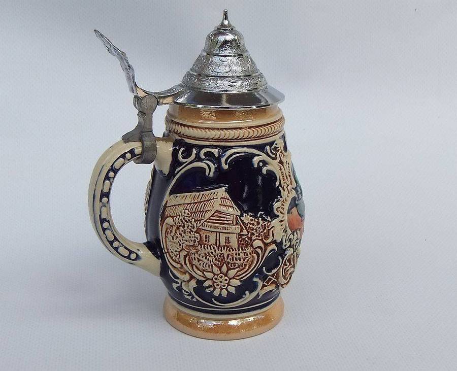 A fabulous vintage German beer stein with hinged metal lid and great detail