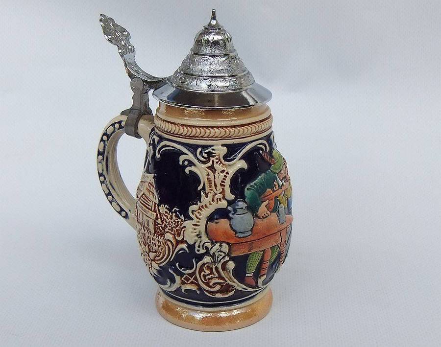 A fabulous vintage German beer stein with hinged metal lid and great detail
