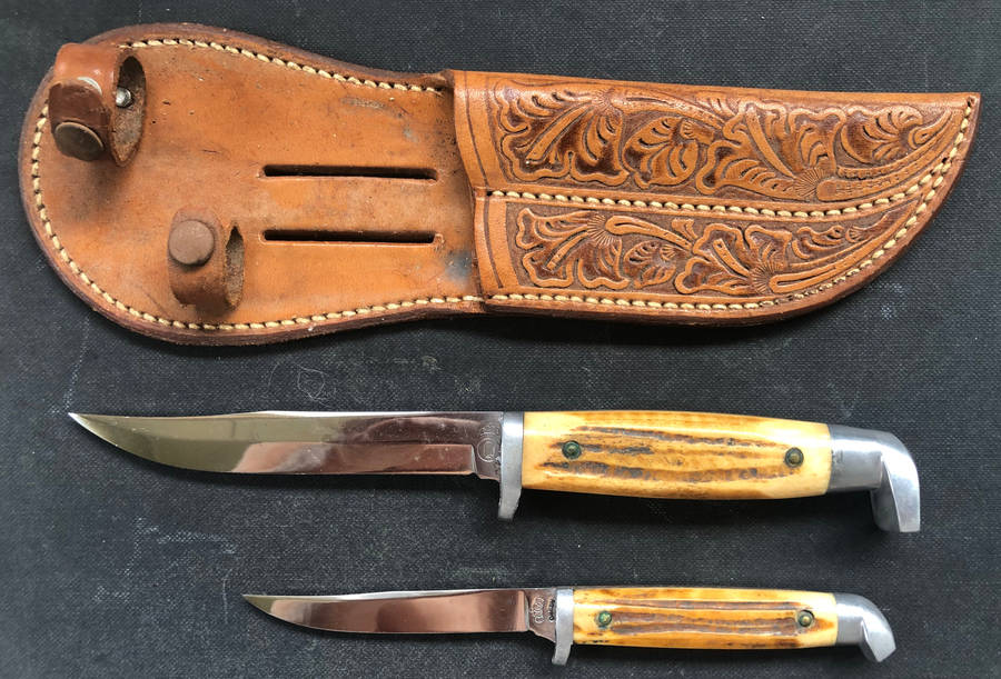 KNIVES PAIR HUNTING KNIVES IN ORIGINAL LEATHER SHEATH SIGNED QUEEN CUTLERY WITH TYPICAL BONE HANDLES