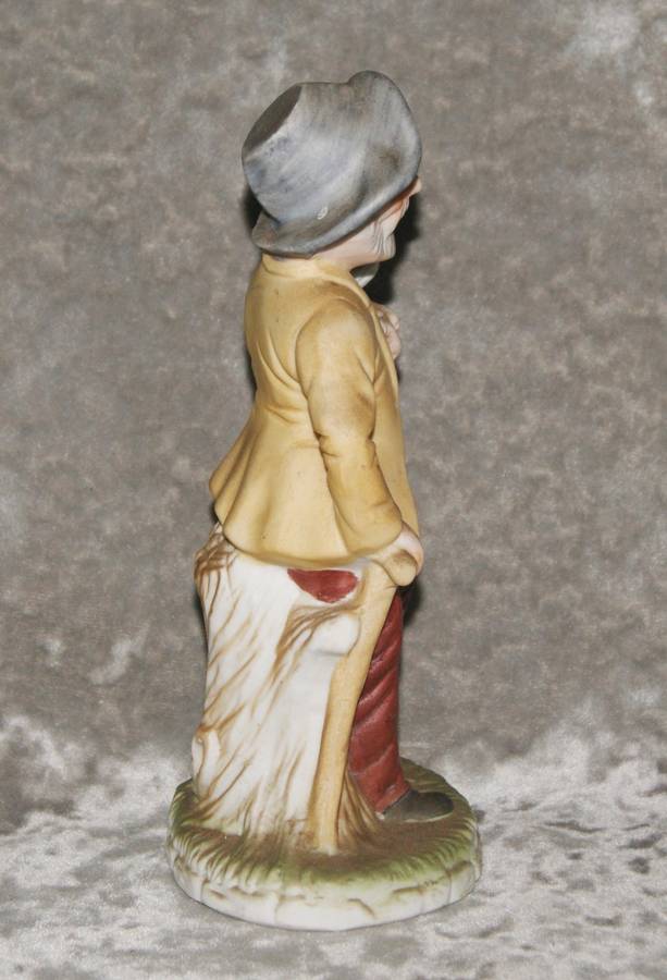 Vintage ceramic figurine of man holding dog