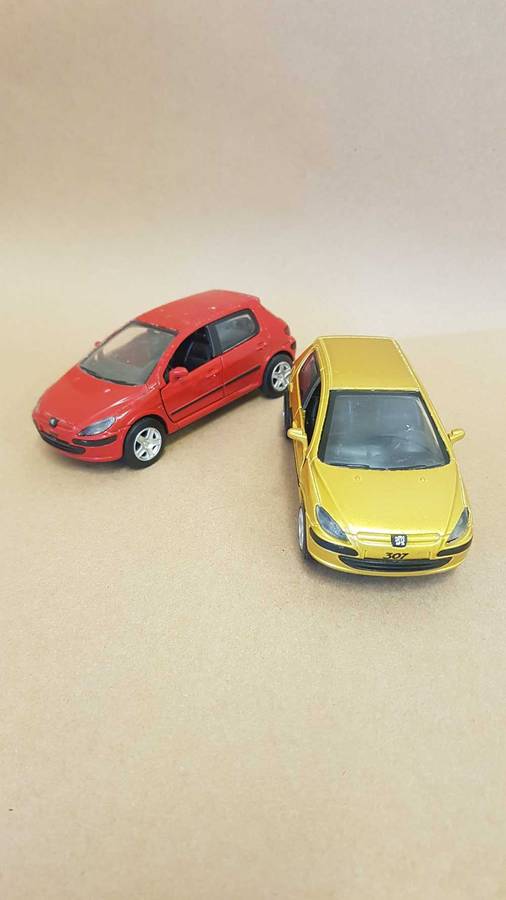 Two Peugeot 307 scale model cars. Dated 2002.