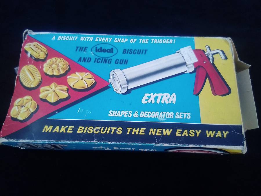 "Ideal" Biscuit and Icing Gun.  Metal trigger, tube and attachments are hard, white plastic.