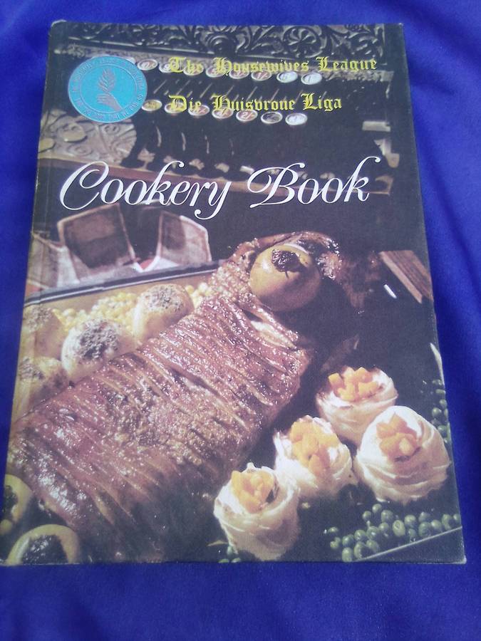 `"Die Huisvroue Liga / The Housewives League Cookery Book" Hard cover.