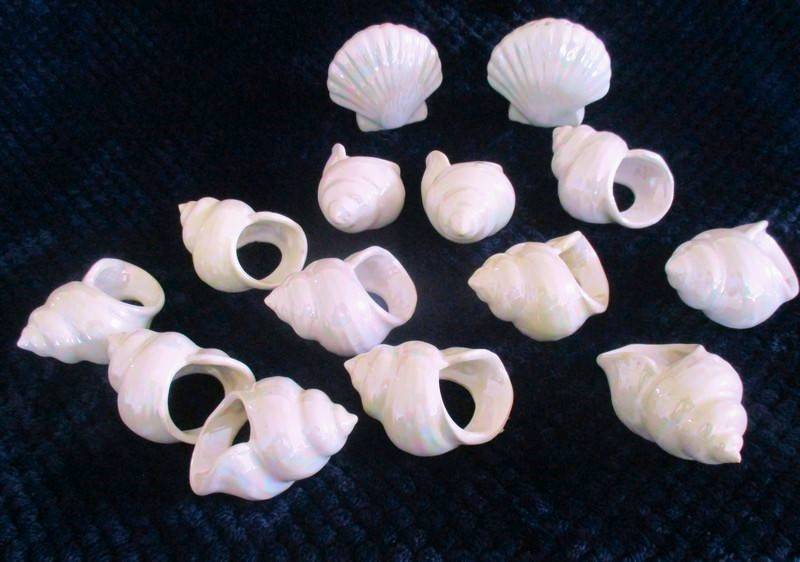 A  set of twelve pearlescent porcelain serviette rings with clam shaped salt and pepper cellars