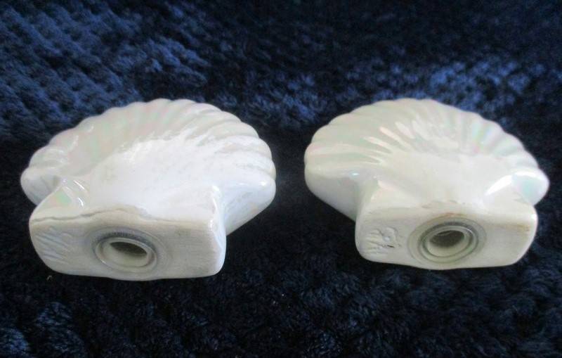 A  set of twelve pearlescent porcelain serviette rings with clam shaped salt and pepper cellars