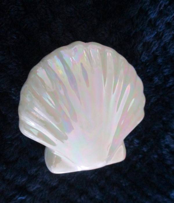 A  set of twelve pearlescent porcelain serviette rings with clam shaped salt and pepper cellars