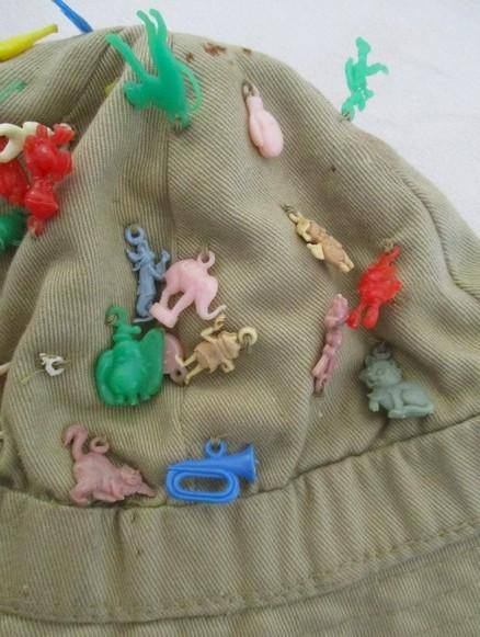 Vintage plastic charms - 62 of them on an old khaki hat!