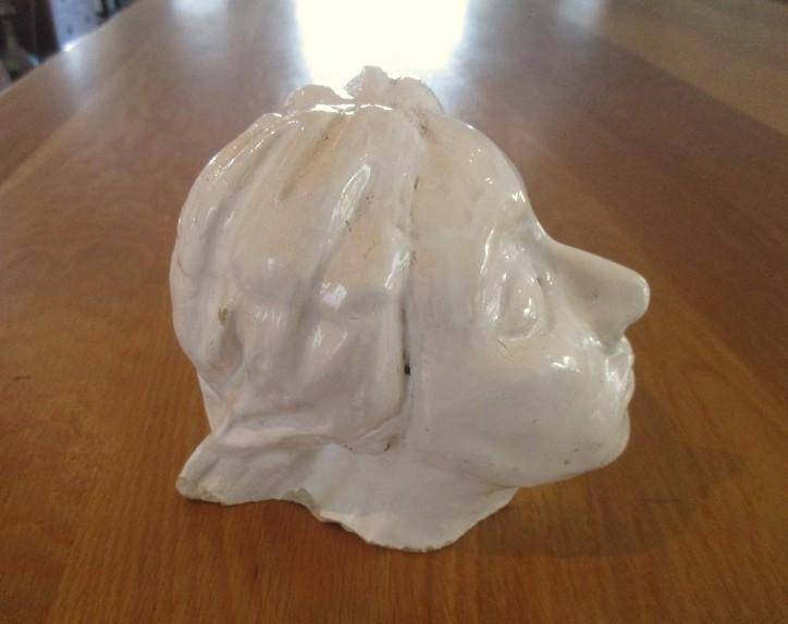 A vintage shabby chic glazed pottery head for inside or outside