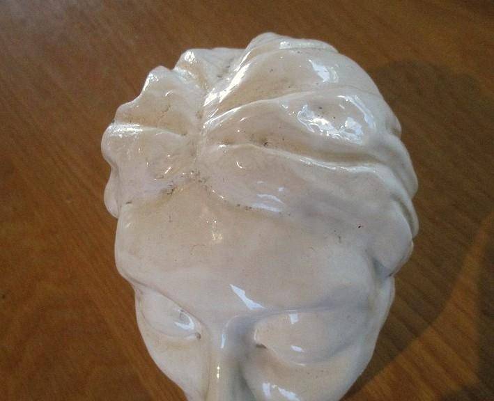 A vintage shabby chic glazed pottery head for inside or outside