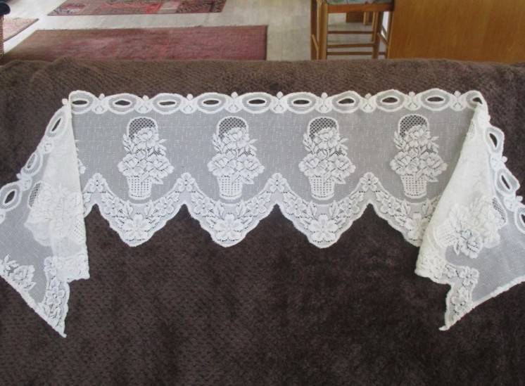 A special vintage `half mast` lace curtain with textured flowers in basket design