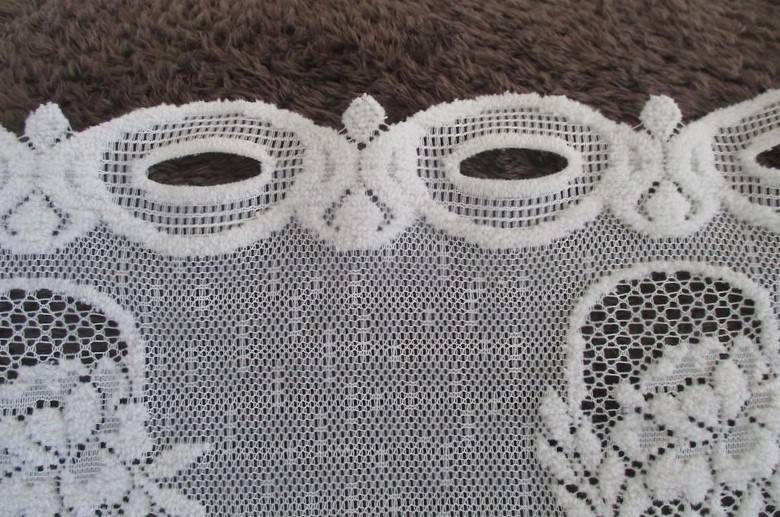 A special vintage `half mast` lace curtain with textured flowers in basket design