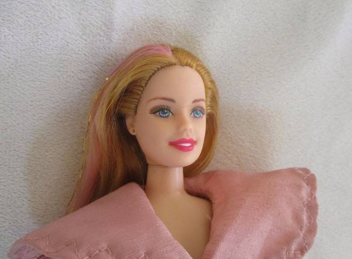 A pretty vintage doll with pink highlights and tinsel in her hair