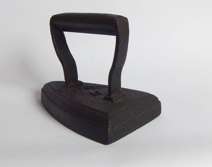 An antique coal stove iron or doorstop