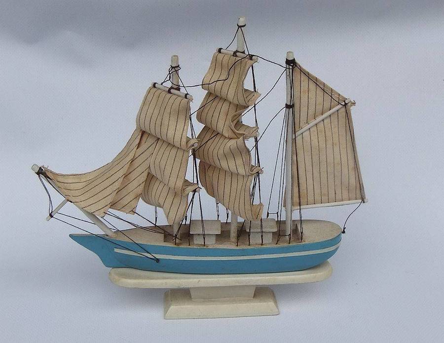 A detailed vintage wooden model of a sail ship with cloth sails