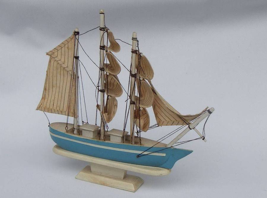 A detailed vintage wooden model of a sail ship with cloth sails