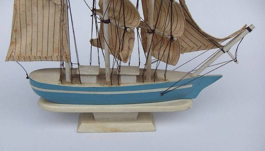 A detailed vintage wooden model of a sail ship with cloth sails