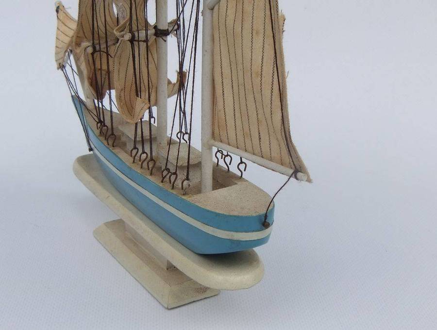 A detailed vintage wooden model of a sail ship with cloth sails