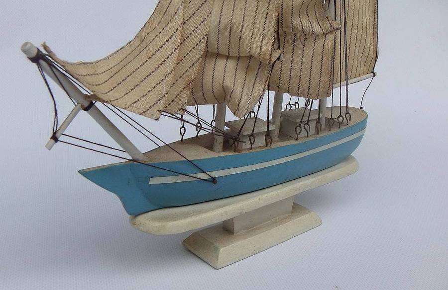A detailed vintage wooden model of a sail ship with cloth sails