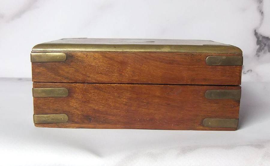 A vintage hand made wooden trinket or jewelry box with brass fittings and inlay