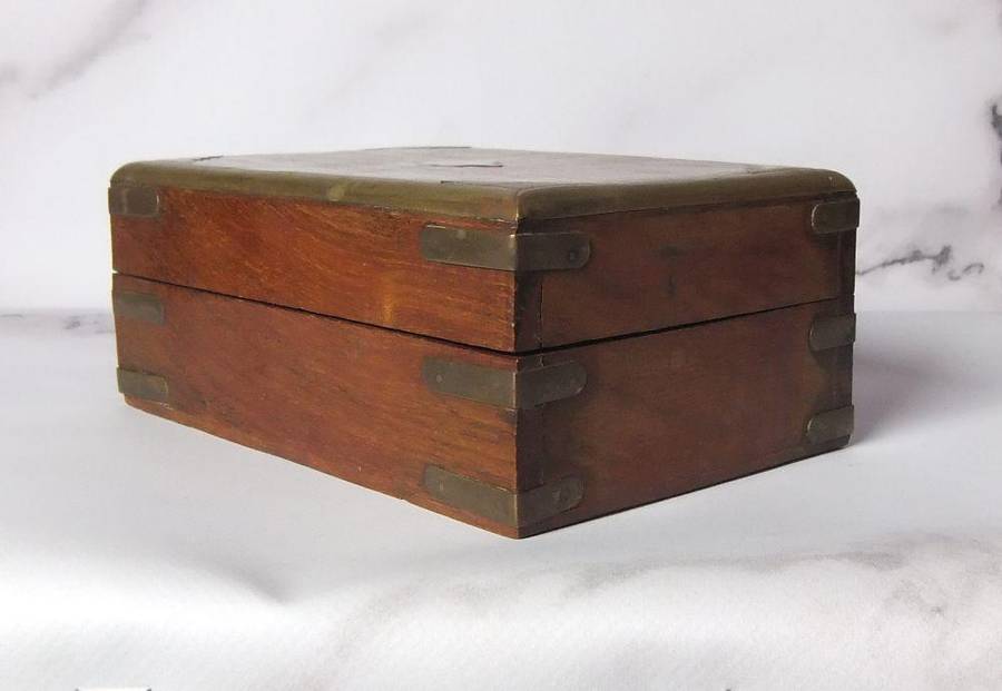 A vintage hand made wooden trinket or jewelry box with brass fittings and inlay