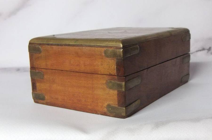 A vintage hand made wooden trinket or jewelry box with brass fittings and inlay