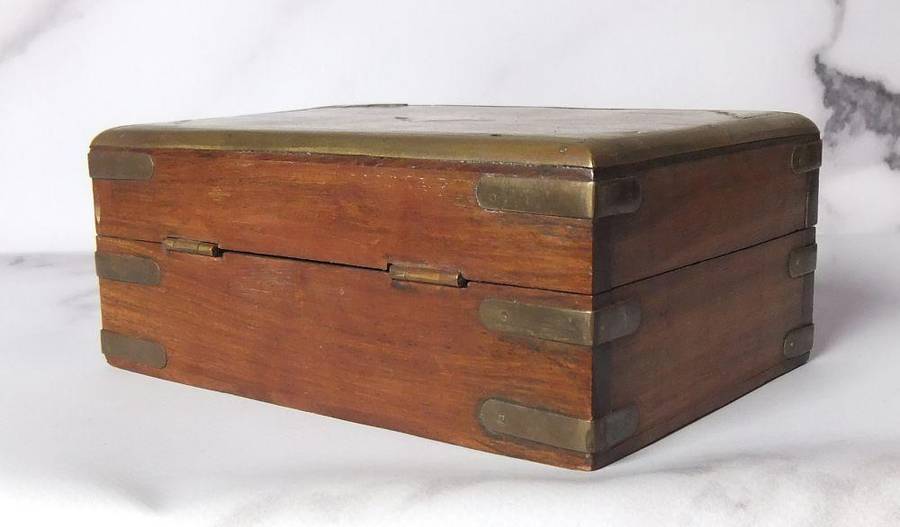 A vintage hand made wooden trinket or jewelry box with brass fittings and inlay