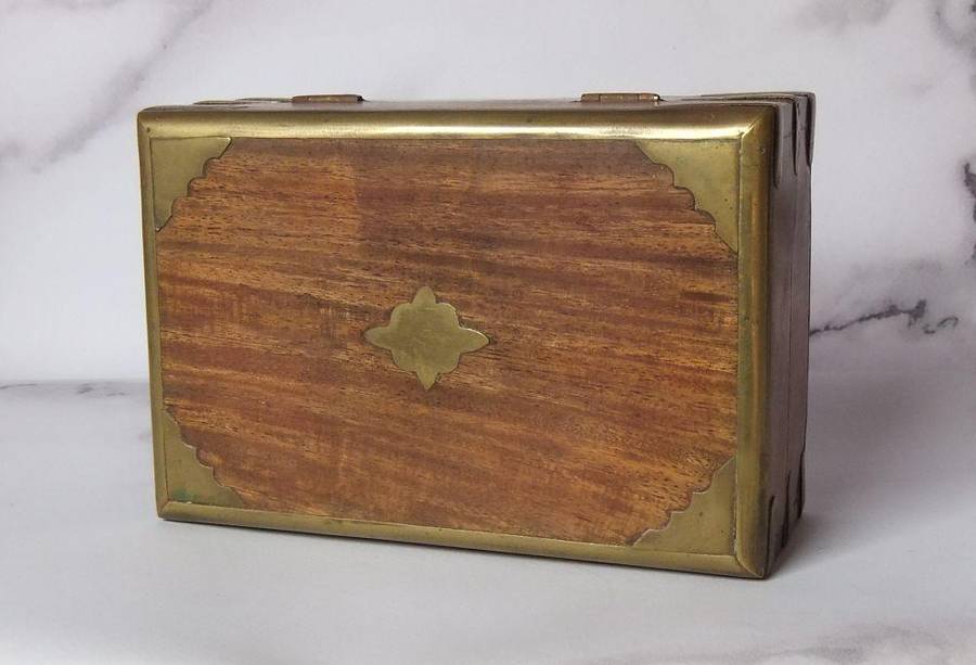 A vintage hand made wooden trinket or jewelry box with brass fittings and inlay