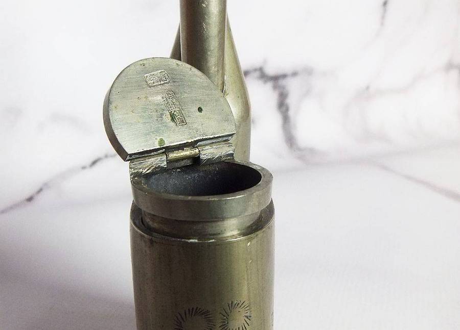 An antique Chinese opium pipe with engraved detail and makers marks for Hong Kong and Rui Xing Long