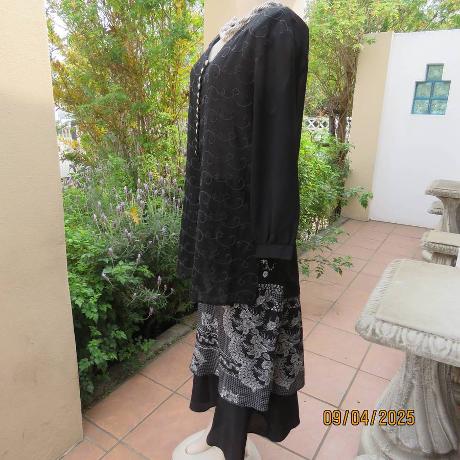 Very black long sleeve sheer top with embroidered front. Front halfway button down. Size 38-40