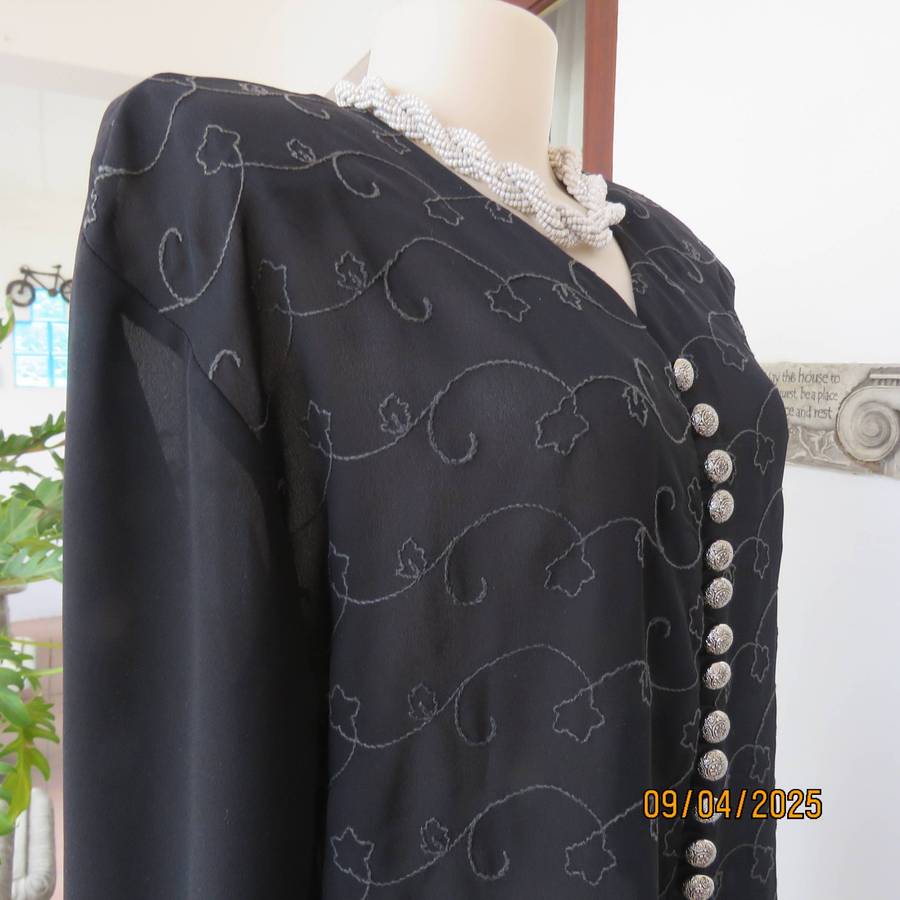 Very black long sleeve sheer top with embroidered front. Front halfway button down. Size 38-40