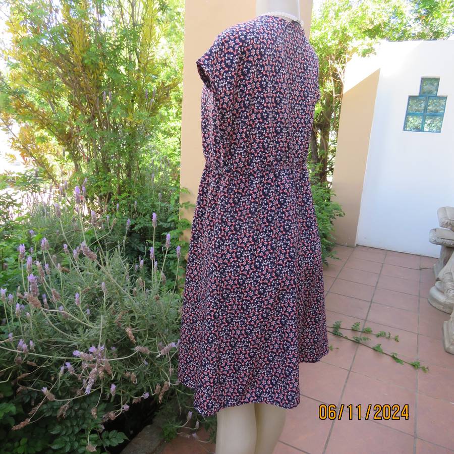 Cool maternity empire style dress in poly-rayon blend.Navy with white-pink flowers.Size 32-34.As new