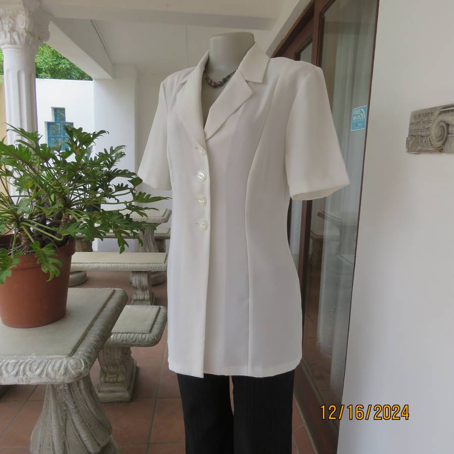 Elegant light cream tailored jacket closing with 4 front buttons. Collar and short sleeves.Size 34