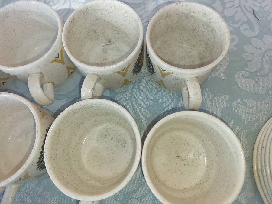 A VINTAGE STONEWARE SUNFLOWER DESIGN 24-PIECE TEACUP AND SAUCER SET