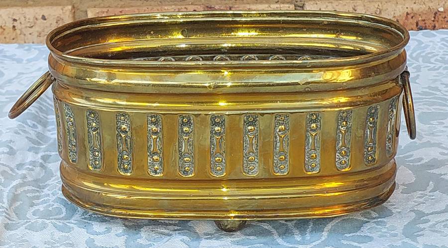 A VINTAGE DOUBLE HANDLED BRASS OVAL PLANTER SOLD AS IS