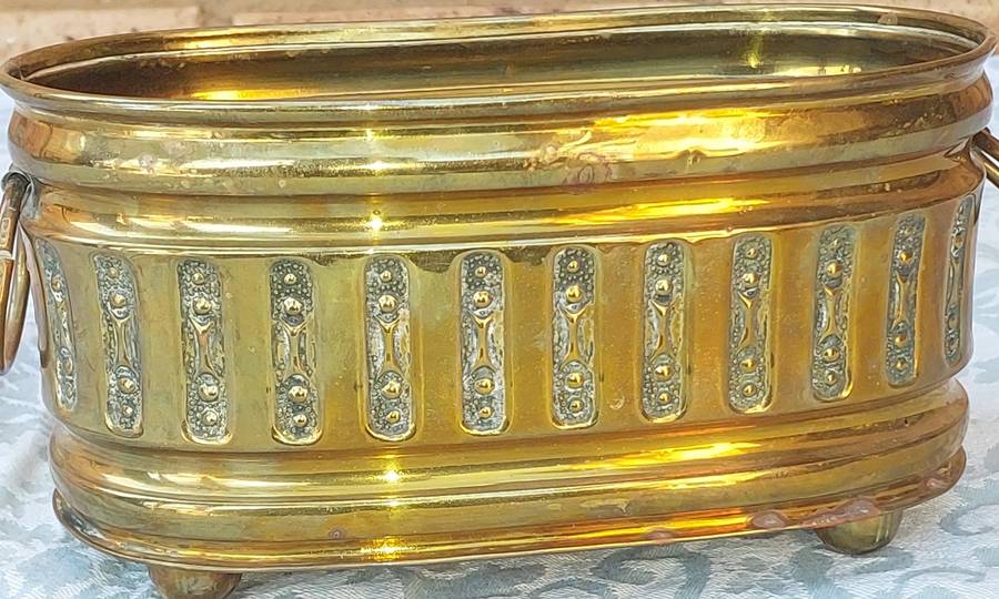 A VINTAGE DOUBLE HANDLED BRASS OVAL PLANTER SOLD AS IS
