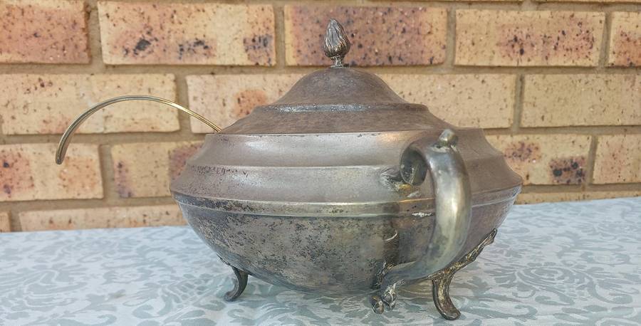 AN ANTIQUE SILVER PLATED TUREEN WITH A LADLE SOLD AS IS
