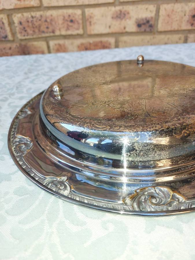 AN ORNATELY ENGRAVED SILVER PLATED SERVING TRAY SOLD AS IS
