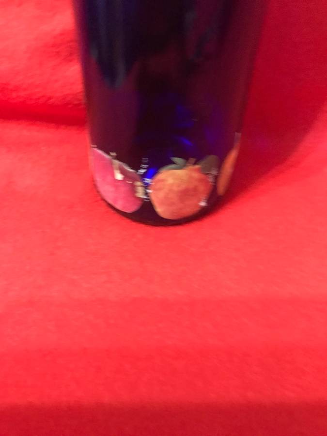 Cobalt bottle with printed apples and has a top