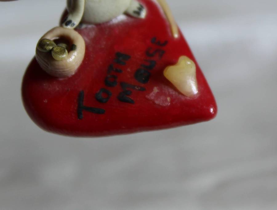 Mini miniature tooth mouse on a heart